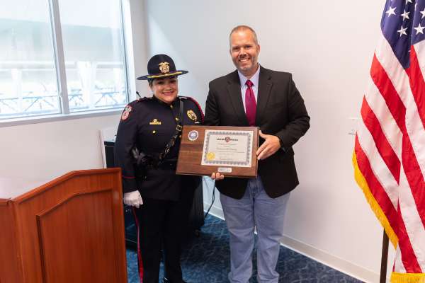 MPD Lieutenant Cleo Sandoval awards a plaque to Lt. Naradovy's family to honor his dedicated service at METRO.